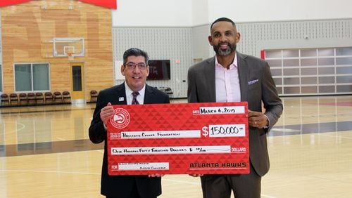 Hawks Vice Chair Grant Hill (right) presents a check for $150,000 to Jonathan W. Simons of the Prostate Cancer Foundation recently. Photo provided.