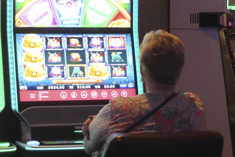 A gambler plays a slot machine at Harrah's casino in Atlantic City N.J., on Sept. 29, 2023. Figures released by New Jersey gambling regulators on April 8, 2024, show Atlantic City's nine casinos collectively reported a gross operating profit of $744.7 million in 2023, a decline of 1.6% from 2022. (AP Photo/Wayne Parry)
