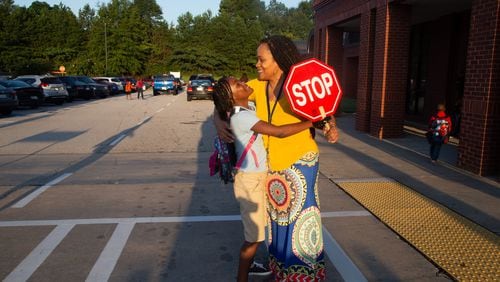 A Clayton County teacher gets a hug from a student on the first day of school Monday, Aug. 6, 2018, in Jonesboro.  (Steve Schaefer for The Atlanta Journal-Constitution)