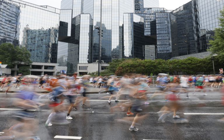 Runners are a blur as they take off up Peachtree Street during the 54th running of the Atlanta Journal-Constitution Peachtree Road Race in Atlanta on Tuesday, July 4th, 2023.   (Miguel Martinez / Miguel.Martinezjimenez@ajc.com)