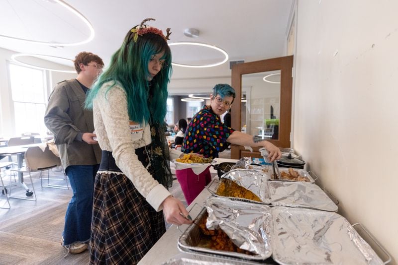 Angelica and Snowflake get food at a Friendsgiving Potluck hosted by Southern Fried Queer Pride at Neighborhood Church in Atlanta, GA, on Sunday, November 20, 2022.(Photo/Jenn Finch)