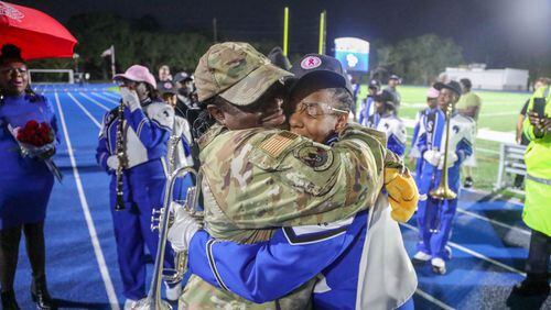 Chief Master Sergeant Alicia Stewart of the 165th Airlift Wing, embraces her daughter Alayna Duke after surprising her following the Savannah High School Marching Band halftime performance on Friday, October 13, 2023 at Savannah High Stadium.