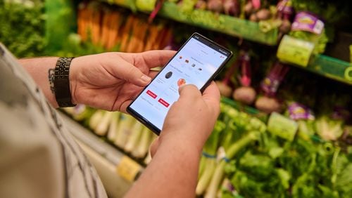 Josh Roberts, who uses Klarna, a buy-now, pay-later service, scrolls through Safeway’s app at one of the grocer’s stores near his home in Kenmore, Wash., July 19, 2022. Chona Kasinger/The New York Times