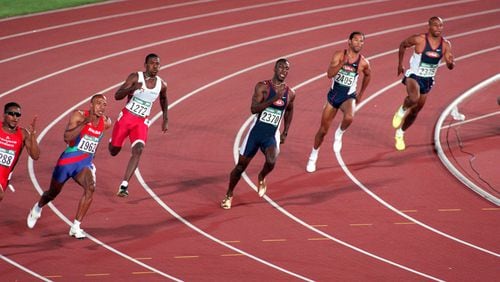 Michael Johnson (center) powers thru the final curve of the 200-meter event at the Olympic Stadium. (Cox Staff Photo/David Cruz)
