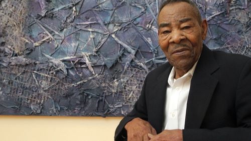 The late Thornton Dial poses with his monumental painting, “Crossing Waters,” during the 2012 opening of “Hard Truths,” a major retrospective staged at the High Museum of Art surveying 20 years of the artists’s work. PHIL SKINNER /