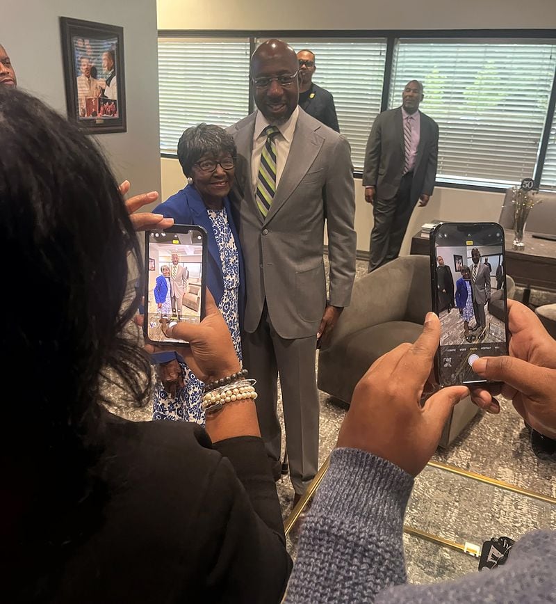 Sen. Raphael Warnock takes a picture with Sally Williams, who was his English teacher at the Sol C. Johnson High School in Savannah, where he grew up with 11 siblings. (Tia Mitchell / Tia.Mitchell@ajc.com)