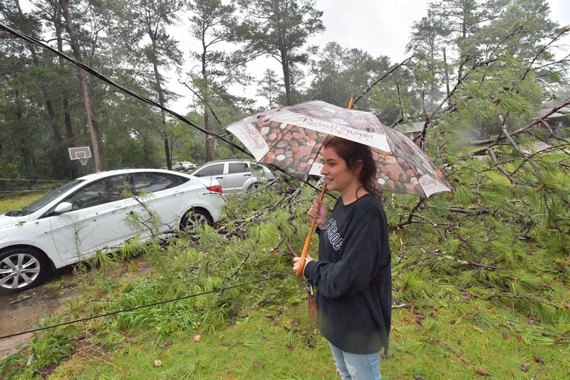September 11, 2017 Columbus - Monica Ogle watches a fallen tree damaged her and her finance's cars at their home in west of Columbus on Monday, September 11, 2017. He had to move his car to a safe parking spot. About 30,000 customers lost power in Columbus. HYOSUB SHIN / HSHIN@AJC.COM