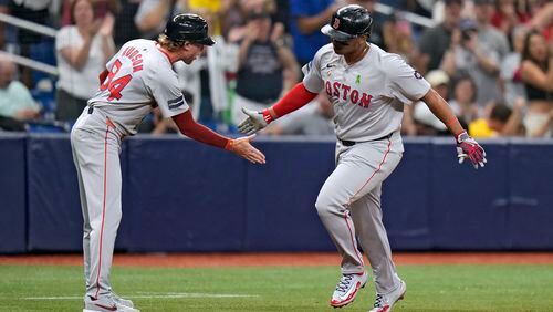 Boston Red Sox's Rafael Devers celebrates with third base coach Kyle Hudson (84) after his two-run home run off Tampa Bay Rays starting pitcher Taj Bradley during the fourth inning of a baseball game Monday, May 20, 2024, in St. Petersburg, Fla. (AP Photo/Chris O'Meara)