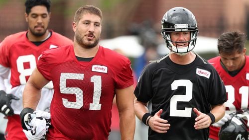 Falcons center Alex Mack and Matt Ryan sprint onto the field for team practice at training camp on Tuesday, Aug. 9, 2016, in Flowery Branch.