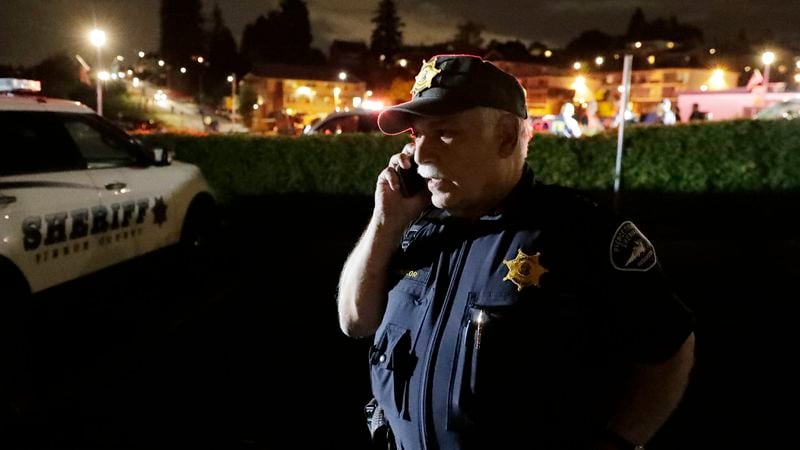Pierce County Sheriff Paul Pastor talks on his phone at a staging area, Friday, Aug. 10, 2018, at the ferry terminal in Steilacoom, Wash., near where the Coast Guard responded to the Horizon plane crash.