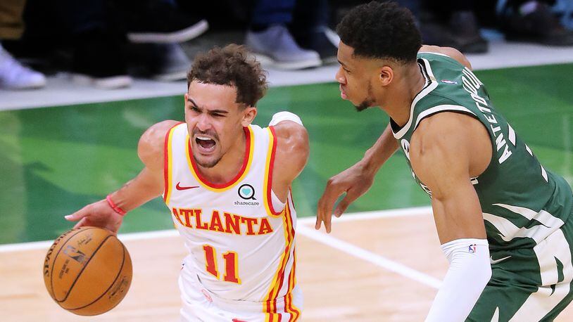 Hawks guard Trae Young drives past Milwaukee Bucks defender Giannis Antetokounmpo on his way to the basket during Game 1 of the Eastern Conference finals Wednesday, June 23, 2021, in Milwaukee. (Curtis Compton / Curtis.Compton@ajc.com)
