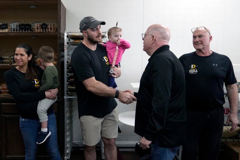 Former Maryland Gov. Larry Hogan, second from right, shakes hands with Andrew DePaola during a visit to DePaola's Bagel and Brunch in Stevensville, Md., Friday, April 12, 2024, as Hogan campaigns for the U.S. Senate. (AP Photo/Susan Walsh)