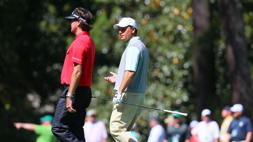 Defending Masters champion Bubba Watson (LEFT) talks with his playing partner Jeff Knox as they walk down the #10 fairway during the third round in the Masters Tournament on Saturday April 13 2013.
