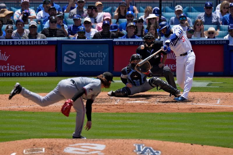Los Angeles Dodgers' Teoscar Hernández, right, hits a two-run home run as Miami Marlins pitcher Ryan Weathers, left, and catcher Nick Fortes, second from left, watch along with home plate Alfonso Marquez during the sixth inning of a baseball game Wednesday, May 8, 2024, in Los Angeles. (AP Photo/Mark J. Terrill)