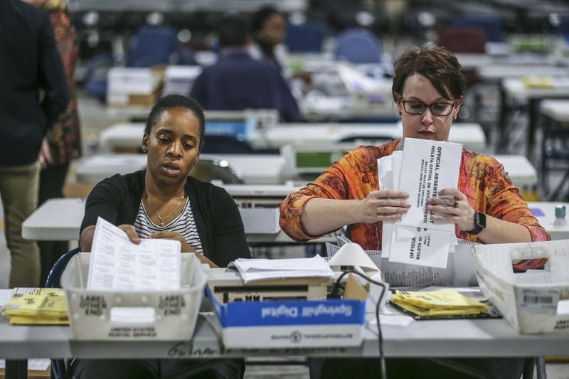 Elections Coordinator Shantell Black, left, and Elections Deputy Director Kristi Royston open and scan absentee ballots in November at the Gwinnett County Voter Registration and Elections Office in Lawrenceville. JOHN SPINK/JSPINK@AJC.COM
