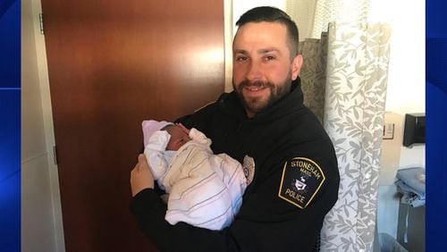 Stoneham policeman Michael Colotti holds the baby he helped deliver late Thursday.