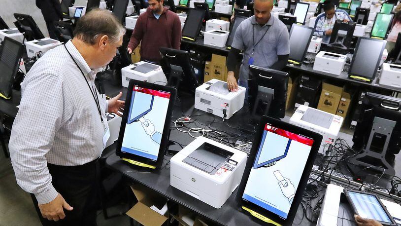 Project manager Tom Feehan looks over some of the state’s new voting machines Tuesday while thousands are tested and packed in a Fulton County warehouse. Curtis Compton ccompton@ajc.com