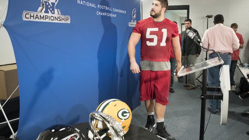 CORRECTS THE LOCATION TO FLOWERY BRANCH, GA. - Atlanta Falcons center Alex Mack looks at an NFL football banner as he arrives for a news conference, Wednesday, Jan. 18, 2017, in Flowery Branch, Ga. The Falcons host the Green Bay Packers in the NFC Championship football game on Sunday. (AP Photo/John Amis)
