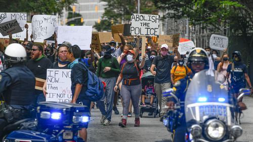 A group of demonstrators marches down Pryor Street, including one with a sign calling for the abolition of police, as they approach Atlanta City Police officers Saturday, June 6, 2020 (Photo:  John Amis for The Atlanta Journal-Constitution)