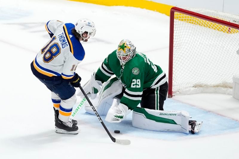 Dallas Stars goaltender Jake Oettinger (29) blocks a shot by St. Louis Blues' Robert Thomas (18) during the shootout in an NHL hockey game in Dallas, Wednesday, April 17, 2024. (AP Photo/Tony Gutierrez)