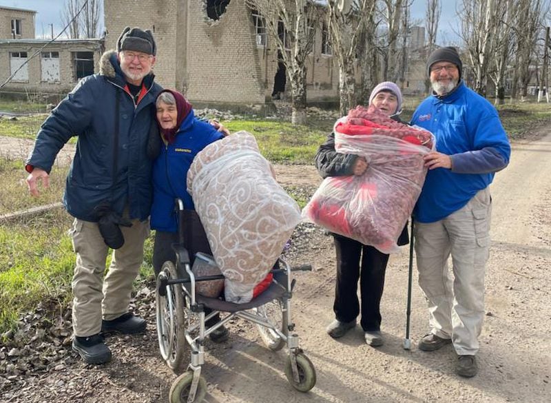 Atlantan Ken Ward (right) stands with three displaced Ukrainians in Kherson, Ukraine. Courtesy of HelpingUkraine.U.S.