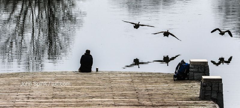 Pat Treemont enjoys warm weather while watching the waterfowl at Piedmont Park. JOHN SPINK / JSPINK@AJC.COM