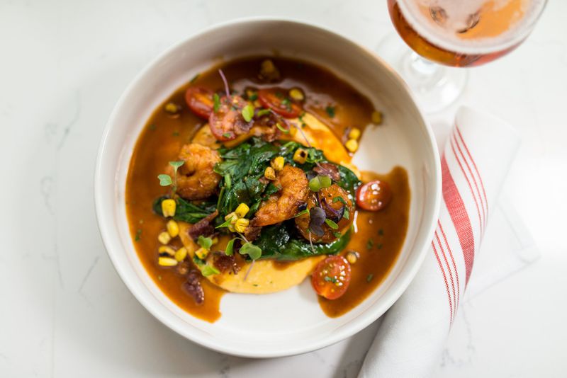 Shrimp and Grits with smoked bacon, tomato, spinach, and a classic Manhattan. Credit: Mia Yakel.
