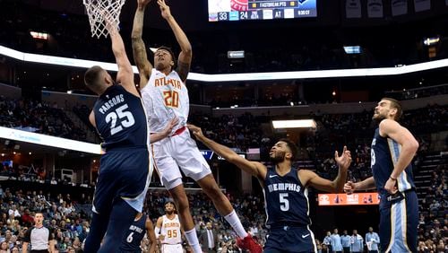 Atlanta Hawks forward John Collins (20) shoots against Memphis Grizzlies forward Chandler Parsons (25) as Grizzlies guard Andrew Harrison (5) and center Marc Gasol, right, move for position in the second half of an NBA basketball game Friday, Dec. 15, 2017, in Memphis, Tenn. (AP Photo/Brandon Dill)
