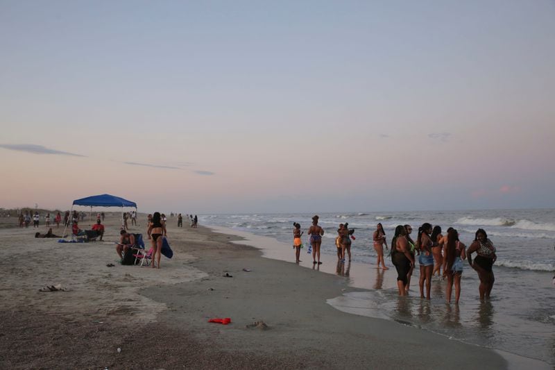 People spending time with their friends at the edge of the water during Orange Crush on Tybee Island, Saturday, April 22