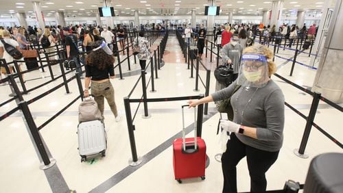 Passengers with face masks and shields wait in the Security Checkpoint Line at the South Terminal of the Atlanta Hartsfield-Jackson International Airport.Tuesday, June 23, 2020. Miguel Martinez for The Atlanta Journal-Constitution