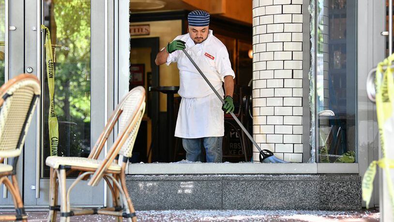 An employee cleans up after a night of riots and looting in Buckhead area at Bistro Niko restaurant on Peachtree Road in Buckhead. AJC Photo: Hyosub Shin