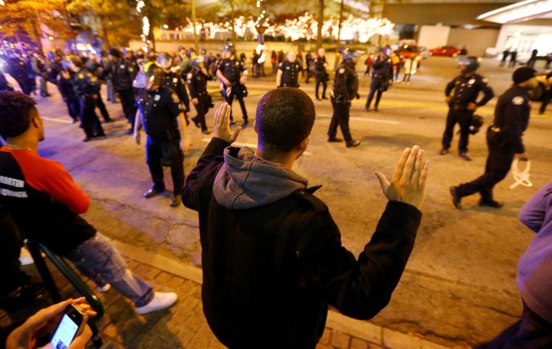 Protesters face off with Atlanta police on Nov. 25, 2014, after they forced them off the road to the sidewalk on Peachtree Street in the wake of the grand jury decision not to indict officer Darren Wilson in the shooting death of Ferguson, Missouri, teen Michael Brown. (Photo: CURTIS COMPTON / CCOMPTON@AJC.COM)