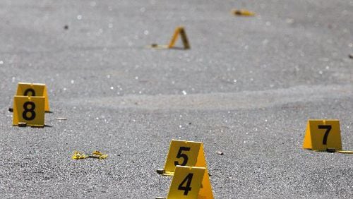 Evidence tags and bullet casings lay on a crime scene near where a body was found in 2015, in DeKalb County, Ga. SPECIAL / BRANDEN CAMP