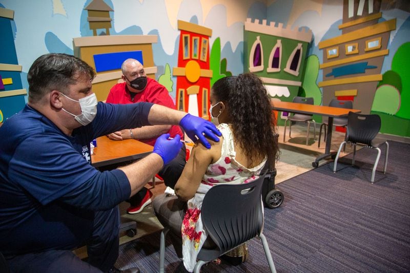 Paramedic Jonathan Cusick gives Christi Giddens her first COVID-19 shot in the children's room of the Impact Church in Atlanta earlier this week. (Steve Schaefer for The Atlanta Journal-Constitution)