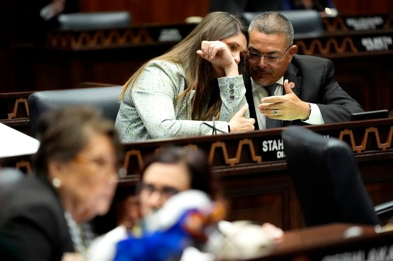 Arizona State Rep. Lupe Contreras, D, right, speaks with Stephanie Stahl Hamilton, D, on the House floor, Wednesday, April 17, 2024, at the Capitol in Phoenix. House Republicans have again blocked an effort for the chamber to take up legislation that would repeal Arizona’s near-total ban on abortions. (AP Photo/Matt York)