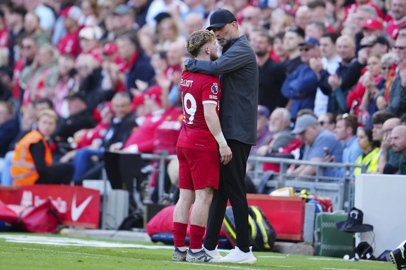 Liverpool's manager Jurgen Klopp, right, hugs Harvey Elliott as he leaves the pitch for substitution during the English Premier League soccer match between Liverpool and Tottenham Hotspur at Anfield Stadium in Liverpool, England, Sunday, May 5, 2024. (AP Photo/Jon Super)