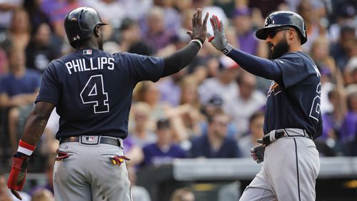 Brandon Phillips (4) of the Atlanta Braves greets Nick Markakis (22) of the Atlanta Braves after the pair scored on double by Matt Adams (18) of the Atlanta Braves against the Colorado Rockies in the seventh inning at Coors Field on August 17, 2017 in Denver, Colorado. (Photo by Joe Mahoney/Getty Images)
