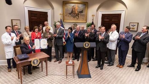 President Donald Trump displays a bill he signed into law Wednesday that outlaws gag clauses that prevent pharmacists from telling patients when they can save money by paying out of pocket. The sponsor of the bill was U.S. Rep. Buddy Carter of Pooler, the only pharmacist serving in Congress. (PHOTO courtesy of the White House)