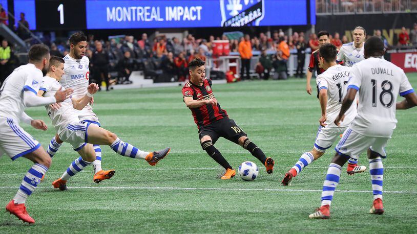 Atlanta United midfielder Miguel Almiron works the ball for a shot on goal against five Montreal Impact defenders during the first half in a MLS soccer game on Saturday, April 28, 2018, in Atlanta.  Curtis Compton/ccompton@ajc.com