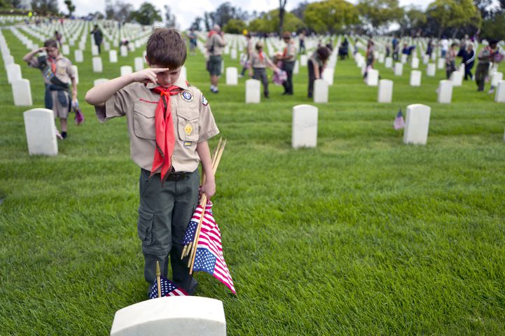scouts place flags at veteran graves to honor memorial day