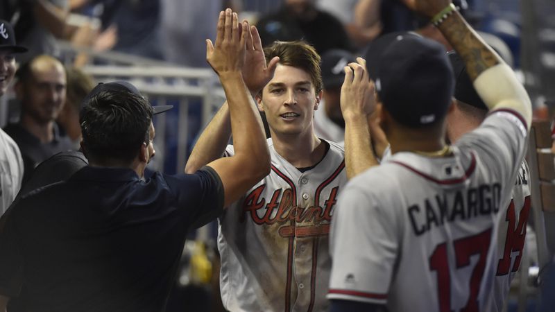 Pitcher Max Fried is congratulated by Braves teammates after scoring as a pinch runner on a double by Ender Inciarte during the 10th inning Sunday, May 5, 2019,in Miami.