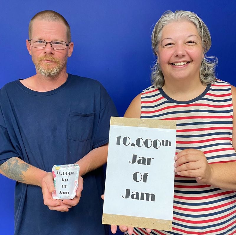 Chris and Jennifer picked up Mike Massey's 10,000th jar of homemade jam from the Lawrenceville Co-Op Food Bank. They are currently homeless and Massey's jam is a big treat for them, they said. The $25 gift card tucked inside was a much needed gift. Courtesy of the Lawrenceville Cooperative Ministry.