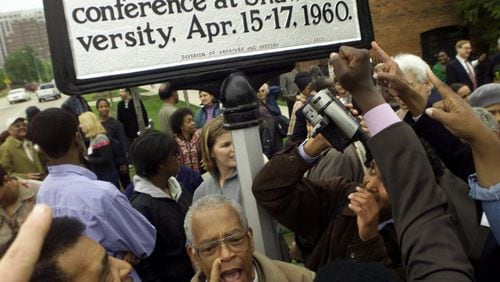 Supporters rally and sing around the unveiling of a historical marker honoring the Student Nonviolent Coordinating Committee (SNCC) on the Shaw University campus in Raleigh, N.C., on April 14, 2000. Prominent in the photo are Chuck Neblett, lower left, and Jim Foreman, beneath marker. (Photo by CHRISTOBAL PEREZ/Raleigh News and Observer)
