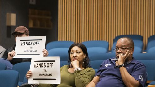 Community members hold up signs reading "Hands off the Promised Land" during the Gwinnett County Board of Commissioners meeting on Wednesday, April 26, 2023, at the Gwinnett Justice and Administration Center in Lawrenceville, Georgia. Several community members addressed the county’s seizure of “The Promised Land” plantation through eminent domain during open comments. CHRISTINA MATACOTTA FOR THE ATLANTA JOURNAL-CONSTITUTION. 