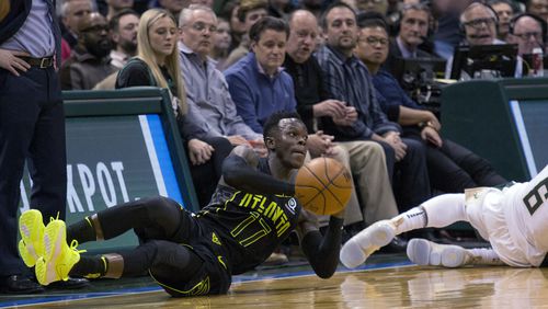 Atlanta Hawks guard Dennis Schroder, left, dives for a loose ball against Milwaukee Bucks guard Eric Bledsoe, right, during the second half of an NBA basketball game Tuesday, Feb. 13, 2018, in Milwaukee. (AP Photo/Darren Hauck)