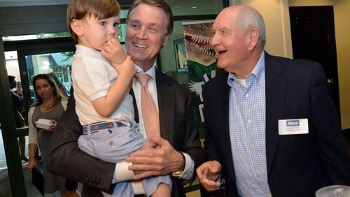 David Perdue holds his grandson, David Perdue IV, as Sonny Perdue looks on during David Perdue’s Election Night party in Buckhead in 2014. (Hyosub Shin / hshin@ajc.com)