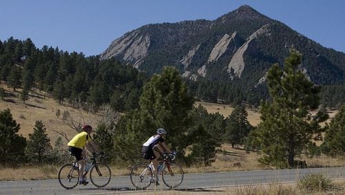 Two bicyclists peddle up Table Mesa Road with the Flatiron rock formation looming in the background in Boulder. Colo. Boulder ranked as the nation’s top happiest city, based in part on its bikability.