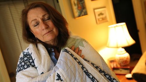 May 4, 2017, Peachtree City: Cancer survivor Roselynn Pearson wraps herself in the comfort and security of a quilt given to her by a fellow guest during her 8-months of treatment at the Atlanta Hope Lodge at her home on Thursday, May 4, 2017, in Peachtree City. Pearson had dropped her insurance coverage, because her pre-existing condition, a congenital heart defect, got excluded from insurance plans so it wasn’t covered; and in addition to that the premiums and deductibles were skyrocketing anyway. But then she got cancer. She counts herself lucky that Obamacare had just come online and she was able to sign up for coverage for her cancer treatment.  Curtis Compton/ccompton@ajc.com