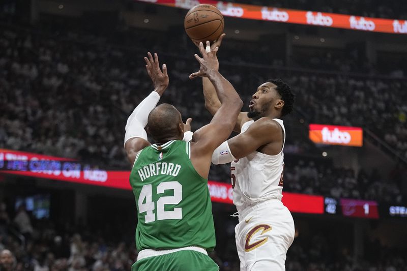 Cleveland Cavaliers guard Donovan Mitchell, right, shoots over Boston Celtics center Al Horford (42) during the first half of Game 3 of an NBA basketball second-round playoff series Saturday, May 11, 2024, in Cleveland. (AP Photo/Sue Ogrocki)