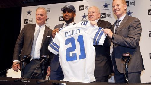Dallas Cowboys NFL football first-round draft pick Ezekiel Elliott, second from left, poses for photos with his new jersey and director of player personnel Stephen Jones, left, team owner Jerry Jones, second from right, and head coach Jason Garrett, right, after a news conference at the team's training facility, Friday, April 29, 2016, in Irving, Texas. (AP Photo/Tony Gutierrez)